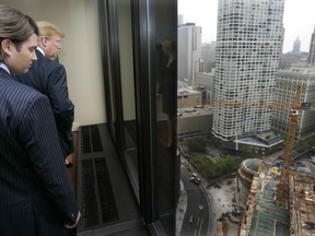 Donald Trump Jr., and his father Donald Trump look out at the construction site of his 92-story residential tower along the Chicago river during a visit to his Chicago offices Wednesday, May 10, 2006. Reflected in the center post is daughter Ivanka. Trump acknowledged that because of security concerns after the events of Sept. 11, he abandoned plans for it to be the worlds tallest building at 150 stories settling for 92 stories. (AP Photo/Charles Rex Arbogast)
