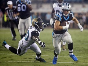 FILE - In this Aug. 24, 2017, file photo, Carolina Panthers running back Christian McCaffrey (22) runs past Jacksonville Jaguars linebacker Telvin Smith, left, during the first half of an NFL preseason football game in Jacksonville, Fla. McCaffrey has been impressive during training camp and the preseason lining up in a number of positions including running back, the slot and even quarterback. (AP Photo/Stephen B. Morton, File)