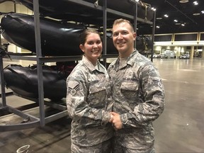 Lauren Durham, left, and Michael Davis, both members of the Air National Guard, pose at the Orange County Convention Center in Orlando, Fla., on Sunday, Sept. 10, 2017. The couple were planning to get married on a beach next weekend but were deployed to assist in the relief efforts for Hurricane Irma. Instead they got married Sunday in fatigues in a vast hangar filled with rescue vehicles and paramedics.  (AP Photo/Claire Galofaro)