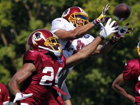 FILE - In this July 31, 2017, file photo, Washington Redskins wide receiver Josh Doctson (18) hauls in a pass in front of cornerback Josh Norman (24) during practice at the Washington Redskins NFL training camp in Richmond,. Va. Doctson is ready to play and eager to show the Redskins why they drafted him in the first round. (AP Photo/Steve Helber, File)