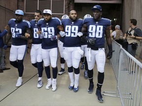 FILE - In this Sept. 24, 2017, file photo, Tennessee Titans' Delanie Walker (82), Marcus Mariota (8), Wesley Woodyard (59), Jurrell Casey (99) and Brian Orakpo (98) walk to the field with arms linked after the national anthem had been played before an NFL football game against the Seattle Seahawks in Nashville, Tenn. Walker says he and his family have received death threats since he told fans not to come to games if they felt disrespected by NFL players' protests. Walker shared the threats Thursday night, Sept. 28, 2017, in a social media post. (AP Photo/James Kenney, File)