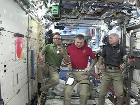 Joe Acaba, left, the first astronaut of Puerto Rican heritage, talks during an interview with The Associated Press alongside Italy's Paolo Nespoli, center, and Mark Vande Hei from the International Space Station on Wednesday, Sept. 20, 2017. Acaba offered words of comfort to Puerto Ricans enduring the wrath of Hurricane Maria. (NASA via AP)