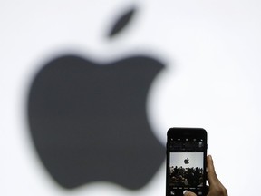 FILE - In this Monday, June 5, 2017, file photo, a person takes a photo of an Apple logo before an announcement of new products at the Apple Worldwide Developers Conference in San Jose, Calif. Apple is expected to demand $1,000 for the fanciest iPhone that it has ever made, thrusting the market into a new financial frontier that will test how much consumers are willing to pay for a device that has become an indispensable part of modern life. (AP Photo/Marcio Jose Sanchez, File)