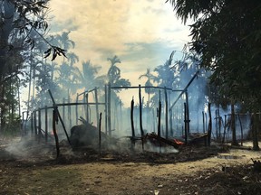 FILE - In this Sept. 7, 2017, file photo, smoke rises from a burned house in Gawdu Zara village, northern Rakhine state, Myanmar. In retaliation for a series of attacks by Rohingya militants in August, security forces and allied mobs have burned down thousands of homes in Northern Rakhine state, where the vast majority of the country's 1.1 million Rohingya lived. (AP Photo, File)