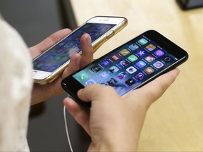 FILE - In this Friday, Sept. 16, 2016, file photo, Lisa Gao compares a black iPhone 7, right, with her iPhone 6 at the Apple Store on Michigan Avenue, in Chicago. Apple, Samsung and other phone companies keep coming out with more powerful phones with better cameras and a bevy of bells and whistles. Rather than relegate an earlier model to a desk drawer, consider donating, reusing, recycling or reselling it. (AP Photo/Kiichiro Sato, File)