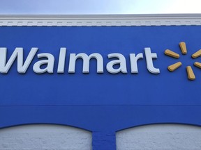 This Thursday, Jan. 5, 2017, photo shows corporate signage at a Walmart in Kissimmee, Fla. Walmart is testing a service that lets a delivery person walk into a customer's home when they're not there to drop off packages or put groceries in the fridge. The retailer says the service is for busy families who don't have time to stop at a store. (AP Photo/Swayne B. Hall)