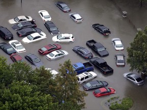 FILE - This Tuesday, Aug. 29, 2017, photo shows flooded cars near the Addicks Reservoir as floodwaters from Harvey rise in Houston. Auto industry experts estimate that 500,000 to 1 million cars, trucks and SUVs were damaged by floodwaters from Hurricane Harvey. Most will have so much water damage that they can't be fixed, and insurance companies will declare them total losses. Yet the damaged cars could be retitled and sold to unsuspecting buyers nationwide. Experts warn against buying the cars because damage could be hidden for years before causing problems. (AP Photo/David J. Phillip, File)