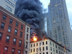 Fire and smoke shoot through roof of a five-story building, in New York, Friday, Sept. 1, 2017. The building has retail space on the first floor and apartments above, in Manhattan's Tribeca neighborhood. (AP Photo/David Caruso)