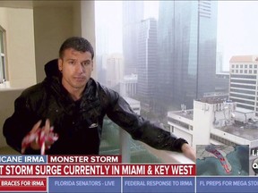 This image taken from video shows ABC's Gio Benitez holding onto a railing while holding a rope for security as he reports on Hurricane Irma from Miami on Sunday, Sept. 10, 2017. (ABC via AP)