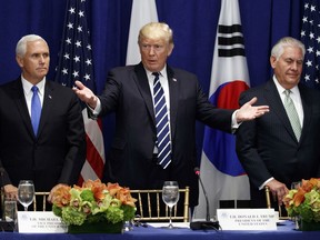 President Donald Trump gestures for people to take their seat at a luncheon with South Korean President Moon Jae-in and Japanese Prime Minister Shinzo Abe at the Palace Hotel during the United Nations General Assembly, Thursday, Sept. 21, 2017, in New York. From left, Vice President Mike Pence, Trump, and Secretary of State Rex Tillerson. (AP Photo/Evan Vucci)