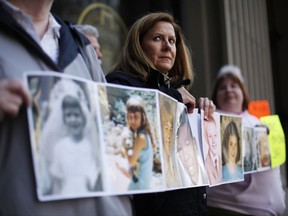 FILE - In this March 29, 2011, file photo, Barbara Blaine, President of Survivors Network of those Abused by Priests (SNAP), displays childhood photographs of adults who say they were sexually abused, during a news conference in Philadelphia. Barbara Blaine, the founder and former president of the Survivors Network of those Abused by Priests, has died. The organization known as SNAP announced on its Facebook page that Blaine died Sunday, Dept. 24, 2017, following a recent cardiac event. She was 61. (AP Photo/Matt Rourke, File)