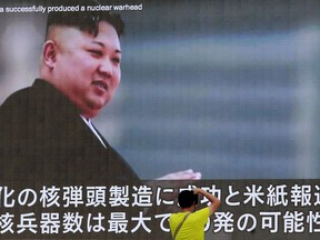 FILE - In this Aug. 6, 2017, file photo, a man takes a photo of a TV news program in Tokyo, showing an image of North Korean leader Kim Jong Un. U.N. experts say North Korea illegally exported coal, iron and other commodities worth at least $270 million to China and other countries including India, Malaysia and Sri Lanka during the six-month period ending in August in violation of U.N. sanctions. (AP Photo/Shizuo Kambayashi, File)