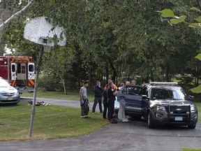 In this Friday, Sept. 8, 2017, photo, police officers take Orion Krause, covered in a white sheet, to a police vehicle in Groton, Mass. The 22-year-old recent Oberlin College graduate and jazz drummer from Maine will face murder charges Monday in the slayings of four adults found at a Massachusetts home. (Courtesy via AP)