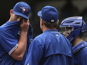 Toronto Blue Jays pitcher Joe Biagini, left, talks on the mound with manager John Gibbons, centre, and catcher Raffy Lopez during the first inning of a baseball game against the New York Yankees on Sept. 29, 2017, in New York.