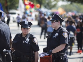 Officers prepare moments ahead of the West Indian Day Parade on Monday, Sept. 4, 2017, in the Brooklyn borough of New York. The parade, one of the largest celebrations of Caribbean culture in the U.S., is being amid ramped-up security. (AP Photo/Kevin Hagen)