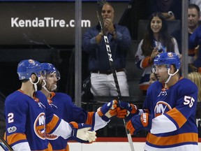 New York Islanders defenseman Nick Leddy (2) and Islanders center Casey Cizikas, second from left, congratulate Islanders defenseman Johnny Boychuk (55) after Boychuck scored an empty-net goal during the third period of a preseason NHL hockey game against the New Jersey Devils in New York, Monday, Sept. 25, 2017. The Islanders shut out the Devils 3-0. (AP Photo/Kathy Willens)