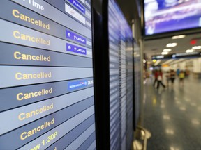 FILE - In this Sept. 8, 2017, file photo, a monitor is shown listing cancelled flights at Miami International Airport in Miami. In addition to residents affected by Hurricane Irma in Florida and the Caribbean, thousands of travelers' vacation plans have been disrupted by cancelled flights, cruises that changed course and hotels and attractions that closed or were damaged by the storm. (Wilfredo Lee/AP Photo, File