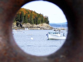 In this Oct. 26, 2013 photo provided by Terry Kole, Bar Harbor, Maine is seen through a rusting boat cleat attached to a dock. The nearby Jordan Pond Shore Trail at the base of Cadillac Mountain in Acadia National Park offers fall colors and a way to get your steps in while enjoying the foliage. (Terry Kole via AP)