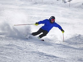 FILE - In this Oct. 29, 2015, file photo, a skier kicks up some fresh powder during opening day at Arapahoe Basin in Dillon, Colo. If you're contemplating a ski vacation this winter, the best deals and discounts typically are offered well before winter. Some options sell out altogether as ski season approaches, especially nonstop flights and stays at ski-in, ski-out properties. (AP Photo/Jack Dempsey, File)