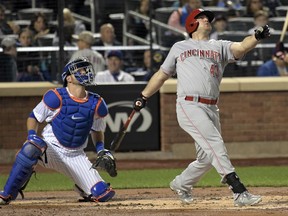 Cincinnati Reds' Scott Schebler hits a sacrifice fly scoring Scooter Gennett as New York Mets catcher Kevin Plawecki, left, looks on during the second inning of a baseball game Saturday, Sept. 9, 2017, in New York. (AP Photo/Bill Kostroun)