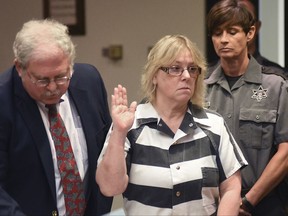 FILE - In this July 28, 2015 file photo, Joyce Mitchell raises her hand during a court appearance in Plattsburgh, N.Y. The state parole board on Friday, Sept. 8, 2017, denied parole to Mitchell, who played a key role in a prison break from the maximum-security state prison in Dannemora in June 2015.  (Rob Fountain/The Press-Republican via AP, Pool, File)