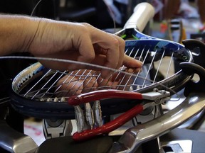 Official Stringer Jarrad Magee works on a tennis racket in the stringing room at the U.S. Open tennis tournament on Thursday, Aug. 31, 2017 in New York. Being part of an elite team of stringers that toils under the stands of Arthur Ashe Stadium for the run of the tournament is a job that comes with frustration, deadline pressure, fussy customers and little thanks. But their reward is in being considered one of the best at what they do, and the pride in seeing their work play out on the game's biggest stage.