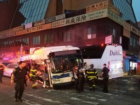 In this photo provided by the NYPD's 109th Precinct, officers respond to a collision involving two buses on Main Street in the Queens borough of New York, Monday, Sept. 18, 2017. The Fire Department of New York said several been hurt, some of them severely, when a city bus and a tour bus collided in the Flushing neighborhood. (NYPD's 109th Precinct via AP)