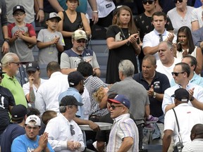 FILE - In this Sept. 20, 2017 file photo, baseball fans react as a young girl is carried out of the seating area after being hit by a line drive during the fifth inning of a baseball game between the New York Yankees and Minnesota Twins at Yankee Stadium in New York. About a third of the 30 major league teams, the Yankees not among them, have extended the netting to protect fans from balls entering the bleachers to at least the end of the dugout. (AP Photo/Bill Kostroun, File)