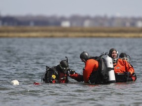 FILE- In this April 14, 2011 file photo, Suffolk County dive team police officers search for possible victims of a suspected serial killer in Hemlock Cove along Ocean Parkway near Cedar Beach, N.Y. On Tuesday, Sept. 12, 2017, Suffolk County Assistant District Attorney Robert Biancavilla said after the sentencing of Long Island carpenter John Bittrolff for the murder of two prostitutes in the early 1990s, that Bittrolff may be responsible for killing at least one of 10 victims whose remains have been found along a Long Island beach highway. (AP Photo/Robert Mecea, File)