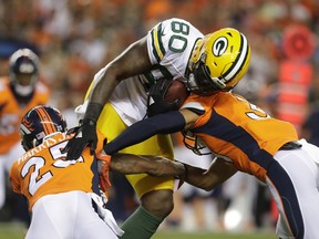 File- This Aug. 26, 2017, file photo shows Green Bay Packers tight end Martellus Bennett (80) being hit by Denver Broncos cornerback Chris Harris (25) during the first half of an NFL preseason football game, in Denver.   So many new veterans for the Green Bay Packers. At their core, the Packers still build through the draft. But general manager Ted Thompson has been more active than usual this season in signing veteran free agents. "Well, I think you have to realize that any time you acquire a player, whether it's through the draft, free agency, regardless of the time of year, it's a process. It's a process that's always going on," coach Mike McCarthy said before practice Wednesday, Sept. 6, 2017. (AP Photo/Joe Mahoney, File)