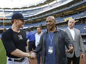 New York Yankees left fielder Clint Frazier left, greets retired heavyweight boxer Mike Tyson before a baseball game against the Tampa Bay Rays at Yankee Stadium in New York, Tuesday, Sept. 26, 2017. (AP Photo/Kathy Willens)