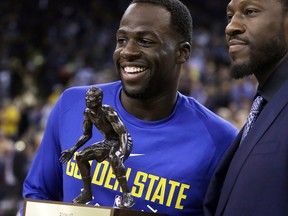 Golden State Warriors' Draymond Green, left, receives the NBA defensive player of the year award from Ben Wallace prior to a a preseason NBA basketball game against the Denver Nuggets Saturday, Sept. 30, 2017, in Oakland, Calif. (AP Photo/Ben Margot)