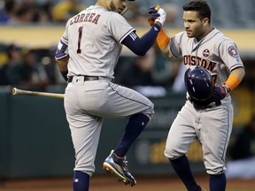Houston Astros' Jose Altuve, right, celebrates with Carlos Correa (1) after hitting a two-run home run off A's Jharel Cotton in the first inning of a baseball game Friday, Sept. 8, 2017, in Oakland, Calif. (AP Photo/Ben Margot)