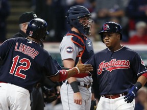 Cleveland Indians' Jose Ramirez gets congratulations from Francisco Lindor (12) after hitting a two run home run off Detroit Tigers starting pitcher Myles Jaye as catcher James McCann stands in the background during the fourth inning in a baseball game, Monday, Sept. 11, 2017, in Cleveland. (AP Photo/Ron Schwane)