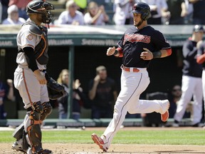 Cleveland Indians' Yan Gomes, right, scores on a one-run double hit by Giovanny Urshela in the third inning of a baseball game against the Baltimore Orioles, Saturday, Sept. 9, 2017, in Cleveland. Catcher Welington Castillo watches. (AP Photo/Tony Dejak)