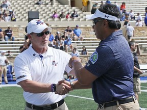 Tulsa head coach Philip Montgomery, left, shakes hands with Navy head coach Ken Niumatalolo, right, before an NCAA college football game in Tulsa, Okla., Saturday, Sept. 30, 2017. (AP Photo/Sue Ogrocki)
