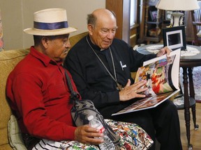 Guatemalan Bishop Julio Edgar Cabrera, right, looks over a Rother Family photo book with Juan Pablo Ixbalan, left, at the Rother Family home in Okarche, Okla, Thursday, Sept. 21, 2017. Stanley Rother, an American priest killed during Guatemala's civil war, is on the path to possible sainthood. Ixbalan knew Rother during his time in Guatemala. A ceremony for Rother's Beatification is scheduled for Saturday, Sept. 23, 2017. (AP Photo/Sue Ogrocki)