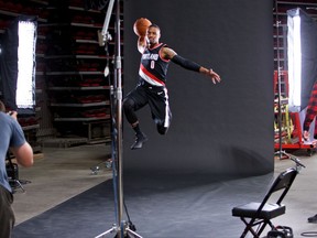 CORRECTS DATE- Portland Trail Blazers guard Damian Lillard, center, is photographed by team photographer Bruce Ely, left, during media day at the Moda Center in Portland, Ore., Monday, Sept. 25, 2017. (AP Photo/Craig Mitchelldyer)