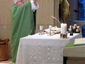 Pope Francis holds up the holy host as he celebrates Mass at the Santa Marta residence, at the Vatican, Tuesday, Sept. 19, 2017. (L'Osservatore Romano/Pool Photo via AP)