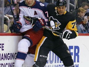 Pittsburgh Penguins' Ryan Reaves (75) checks Columbus Blue Jackets' John Mitchell (7) into the boards during the second period of a NHL preseason hockey game in Pittsburgh, Saturday, Sept. 30, 2017. (AP Photo/Gene J. Puskar)
