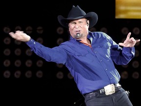 FILE - In this July 8, 2016, file photo, Garth Brooks sings "Ain't Going Down" for his opening song during a performance at Yankee Stadium in New York. Brooks announced on Sept. 27, 2017, a five-part autobiography. The first book will be released in November. (AP Photo/Julie Jacobson, File)