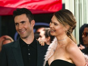FILE - In this Feb. 10, 2017, file photo, Adam Levine, left, and his wife Behati Prinsloo smile at a ceremony that honored him with a star on the Hollywood Walk of Fame in Los Angeles. Levine's publicist confirmed to the AP on Sept. 14, 2017, that the couple is expecting a second child. (Photo by Willy Sanjuan/Invision/AP, File)