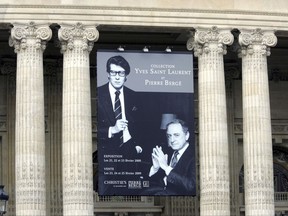 FILE - In this Feb.20, 2009 file photo, the Grand Palais is decorated with a board advertising the auction of the Yves St. Laurent and Pierre Berge collection in Paris. Pierre Berge, an influential French businessman and philanthropist who was fashion designer Yves Saint Laurent's romantic and business partner and championed gay rights, has died at 86.(AP Photo/Remy de la Mauviniere, File)