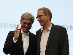 Alstom CEO Henri Poupart-Lafarge, right, and Siemens CEO Joe Kaeser pose during a press conference in Paris, Wednesday, Sept.27, 2017. German industrial equipment maker Siemens AG said Tuesday it has agreed to merge its train-building business with French rival Alstom, creating a "new European champion" in the face of rising competition from China. (AP Photo/Thibault Camus)