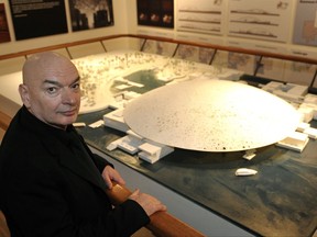 FILE - In this Tuesday, Jan. 15, 2008 file picture, French Architect Jean Nouvel poses in front of a model of the Abu Dhabi Louvre Museum at a cultural exhibition in Abu Dhabi, United Arab Emirates. Sunshine and starlight will dance over visitors to the Louvre Abu Dhabi Museum when it opens in November 2017, filtering through an airy dome with an earthly weight of 7,500 tons - 200 tons more than the iron structure of the Eiffel Tower. Designed by renowned French architect Jean Nouvel, the museum, which sits half in the water, half on terra firma and was built to resemble an Arab village. (Philippe Wojazer/Pool Photo via AP, file)