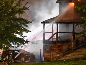 Firefighters battle a fatal house fire in the 400 block of South Fourth Street in Hamburg, Pa., late Saturday night, Sept. 2, 2017. Authorities say a pregnant woman and her two young children were killed in the fast-moving house fire. A man was able to escape from a bedroom window and was hospitalized with injuries. (Michael Yoder/Reading Eagle via AP)