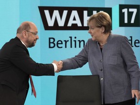 German Chancellor Angela Merkel, head of the Christian Democratic Party CDU, is greeted by her her challenger Martin Schulz, head of the Social Democratic Party SPD, prior to a TV talk of the party leaders in Berlin, Germany, Sunday, Sept. 24, 2017, after the German parliament elections. (AP Photo/Gero Breloer, pool)
