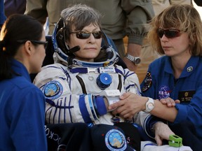 Ground personnel help U.S. astronaut Peggy Whitson after landing in a remote area outside the town of Dzhezkazgan, Kazakhstan, Sunday, Sept. 3, 2017.