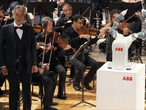 Italian tenor Andrea Bocelli, left, performs Giuseppe Verdi's opera "La Donna e' Mobile", on stage next to the robot YuMi conducting the Lucca Philharmonic Orchestra, at the Verdi Theater, in Pisa, Italy, Tuesday, Sept. 12, 2017. A world famous tenor, a celebrated orchestra and a robot conductor were the highlight of Pisa's inaugural International Robotics Festival which runs from Sept. 7 to Sept. 13. (International Robotics Festival Pisa via AP)