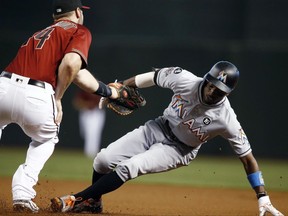 Arizona Diamondbacks' Paul Goldschmidt, left, tags out Miami Marlins' Dee Gordon, right, on a rundown during the first inning of a baseball game Sunday, Sept. 24, 2017, in Phoenix. (AP Photo/Ross D. Franklin)